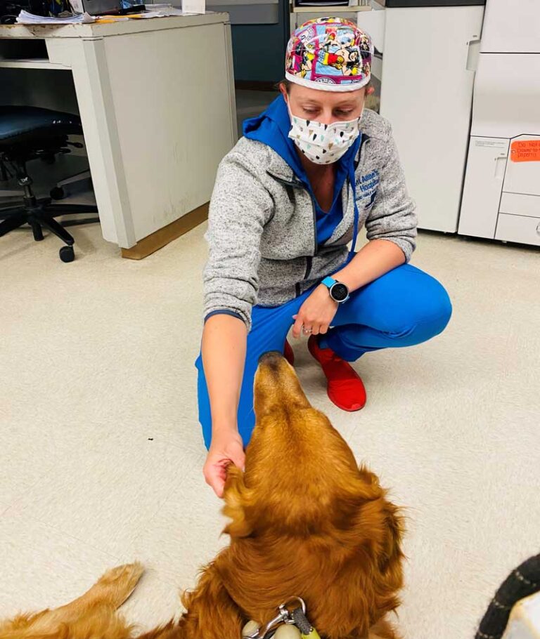 Registered Nurse Rebekah Pack petting a dog.